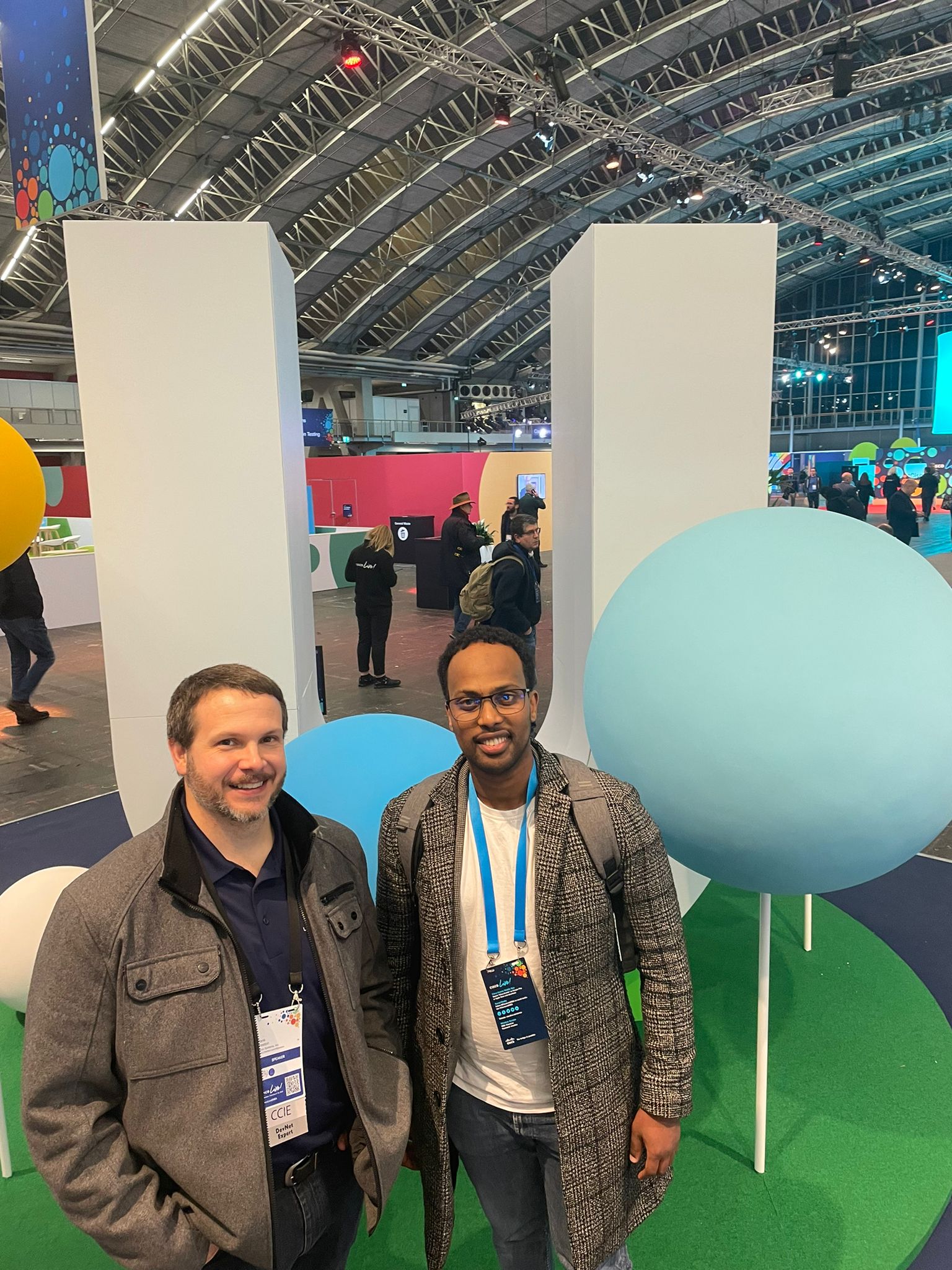 Two people standing in front of a balloon during an IT expo
